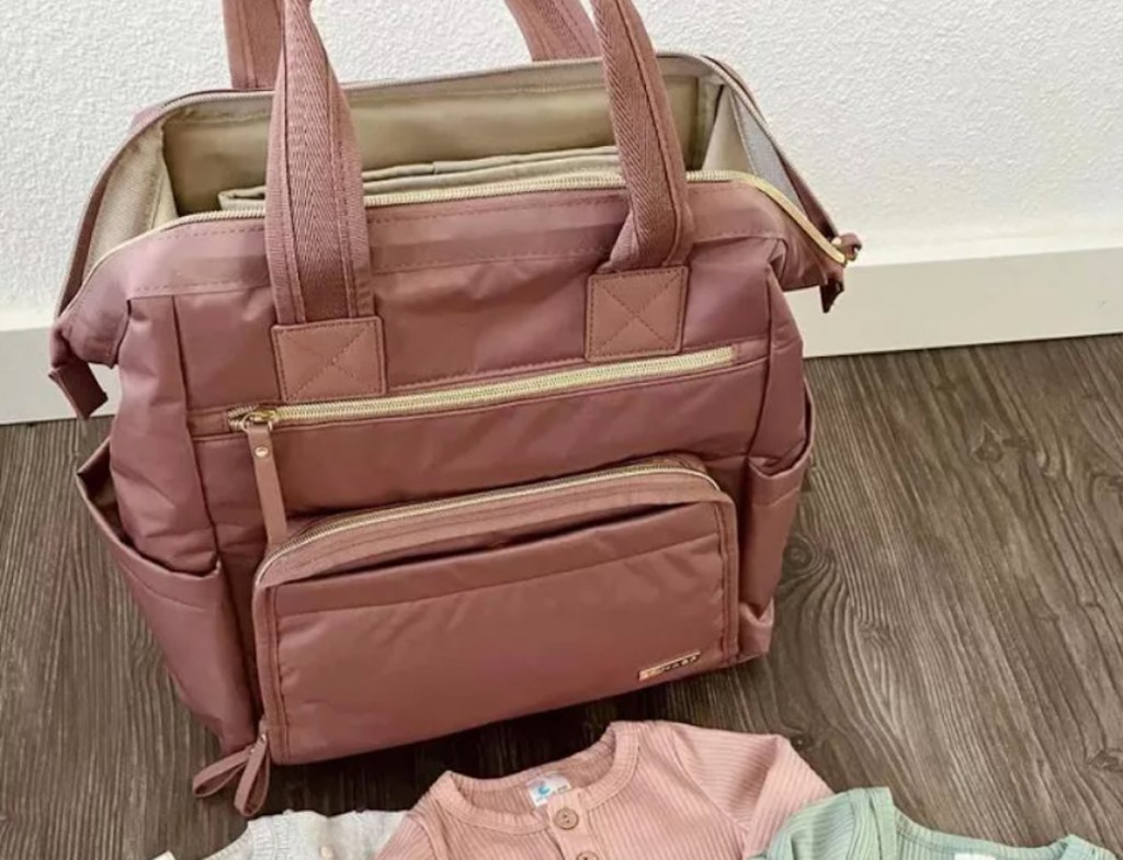 must have pink diaper bag sitting on wooden floor