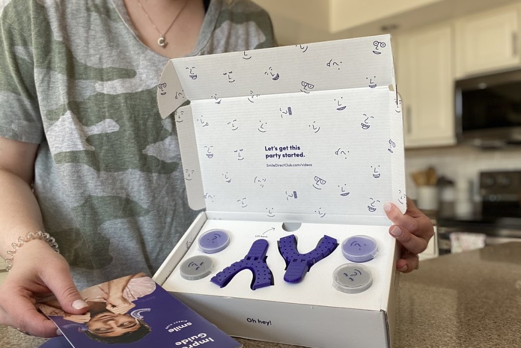 woman holding open smile direct club kit on counter
