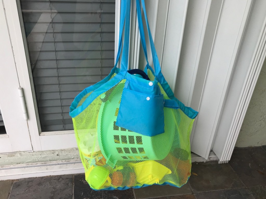 mesh beach bag hanging on sliding glass door