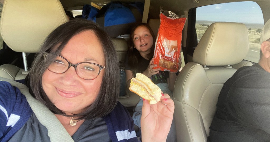 woman eating a sandwich on road trip