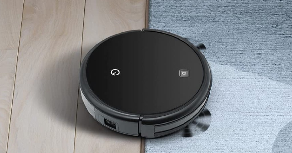 black robot vacuum going from carpet to wood floor