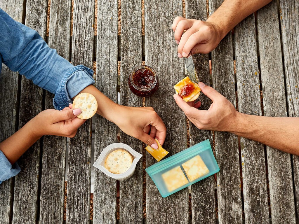 picnic table top with people eating snacks on it