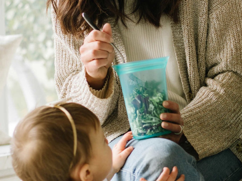 woman feeding baby with a spoon