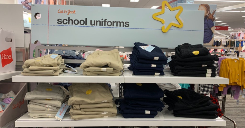 khaki and black uniform bottoms on shelf 