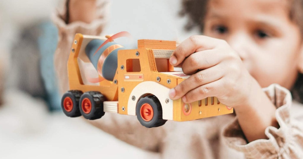 child holding a wood cement truck