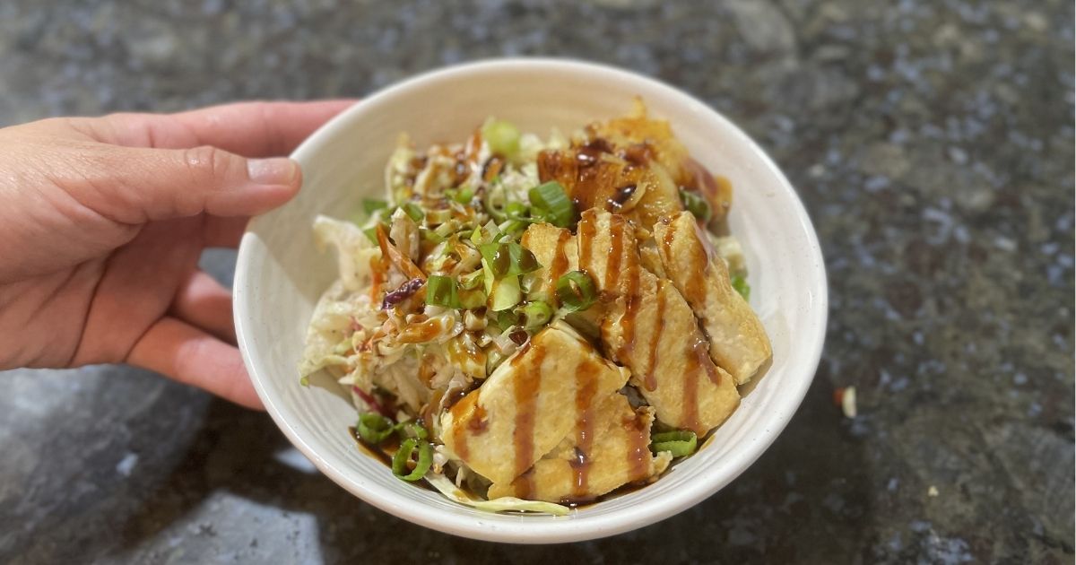 hand holding a bowl with food in it