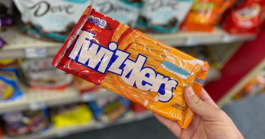 hand holding orange and red pack of candy 