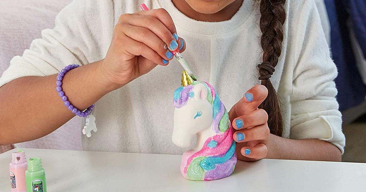 girl painting a unicorn figurine