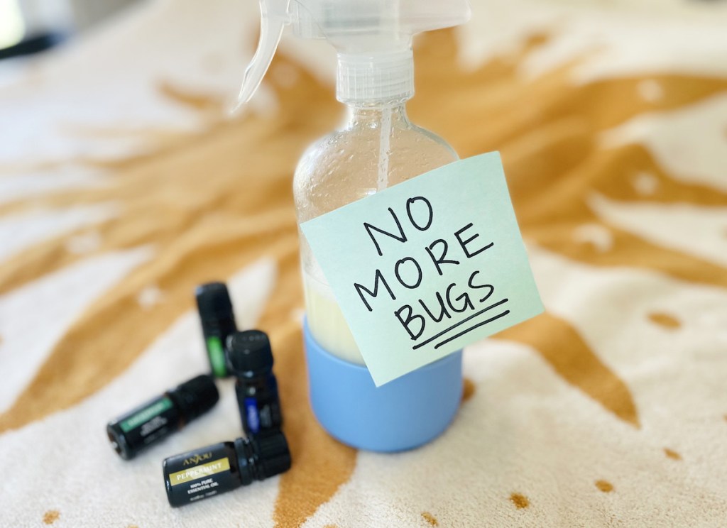 glass bottle with diy bug spray and no more bug sign on front with essential oils