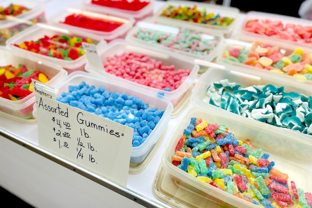 trays full of by the pound candy and gummies