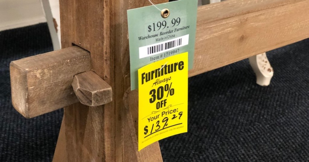 wood table with hobby lobby sale schedule sign on front