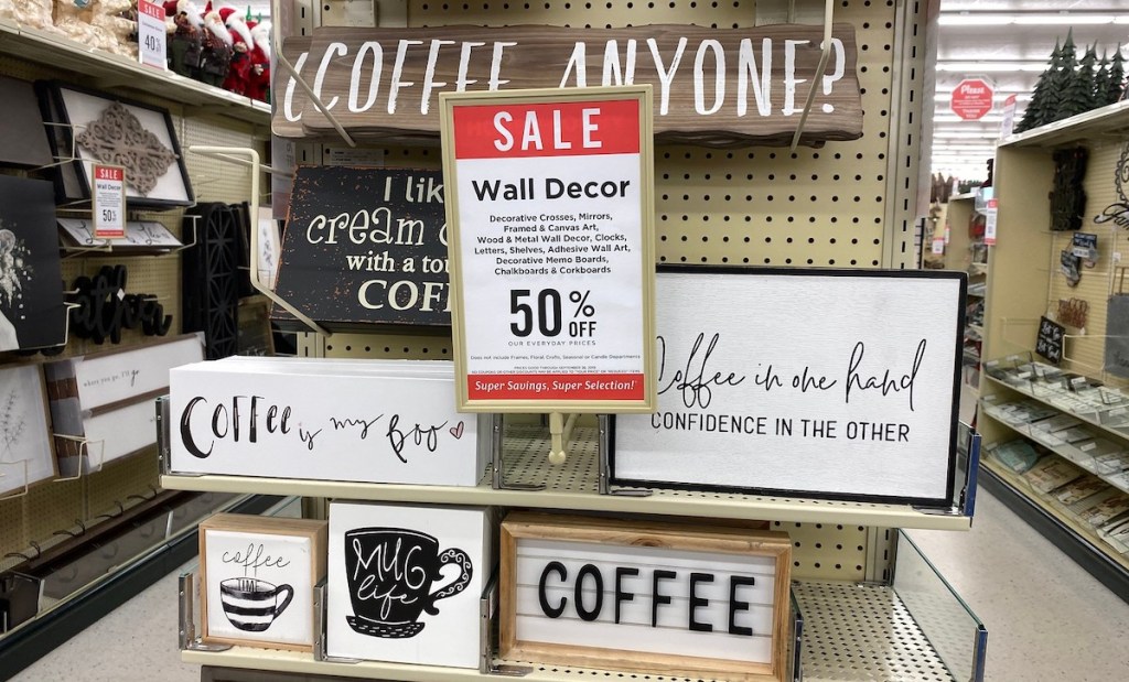 coffee themed wood wall decor hanging on hobby lobby store shelf with sale schedule sign