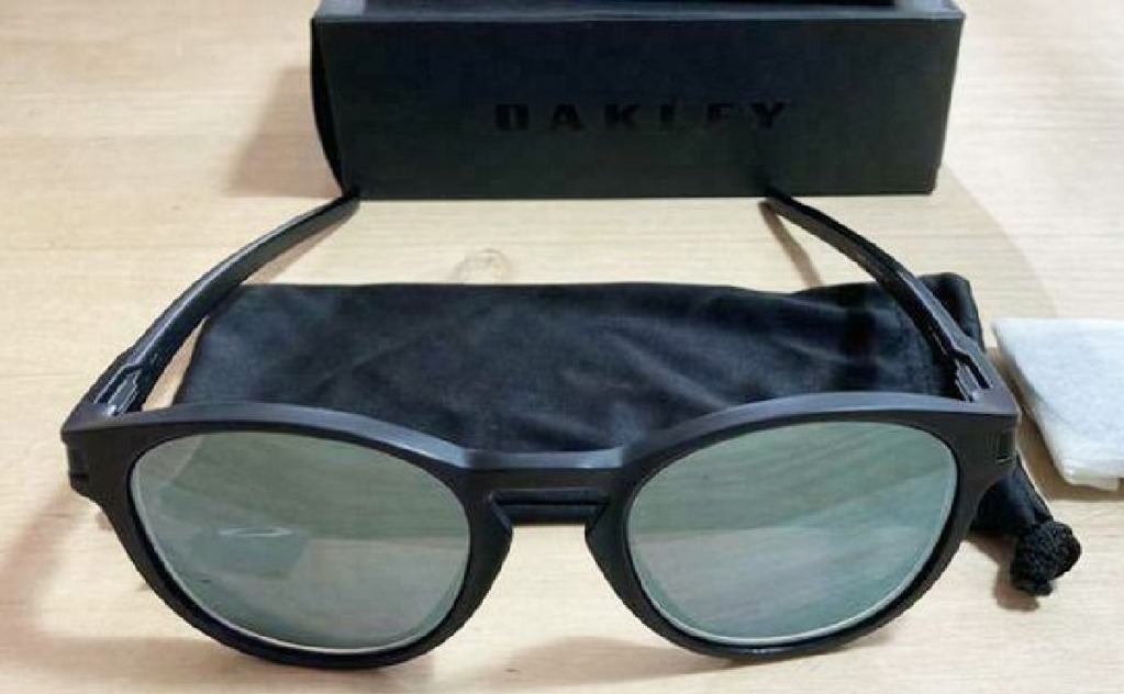 pair of sunglases with black frames sitting on table next to case