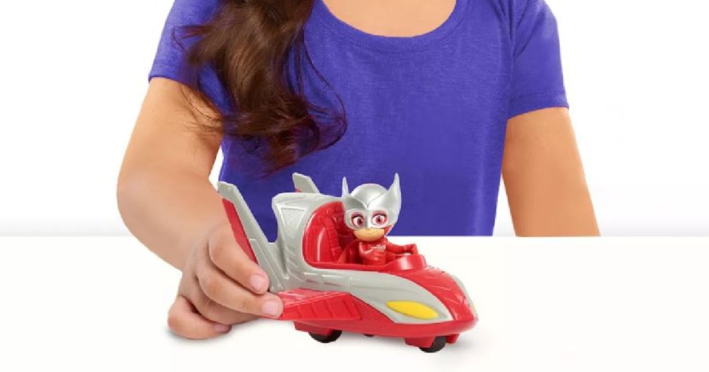 little kid playing with red toy plane/car