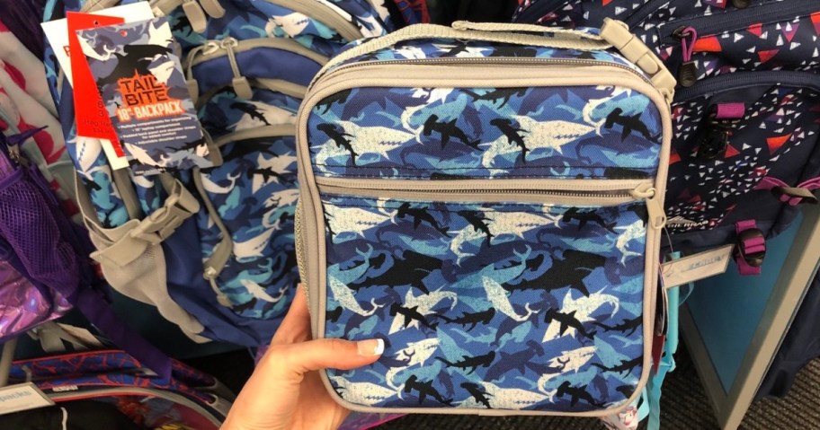 hand holding a shark lunchbox in store