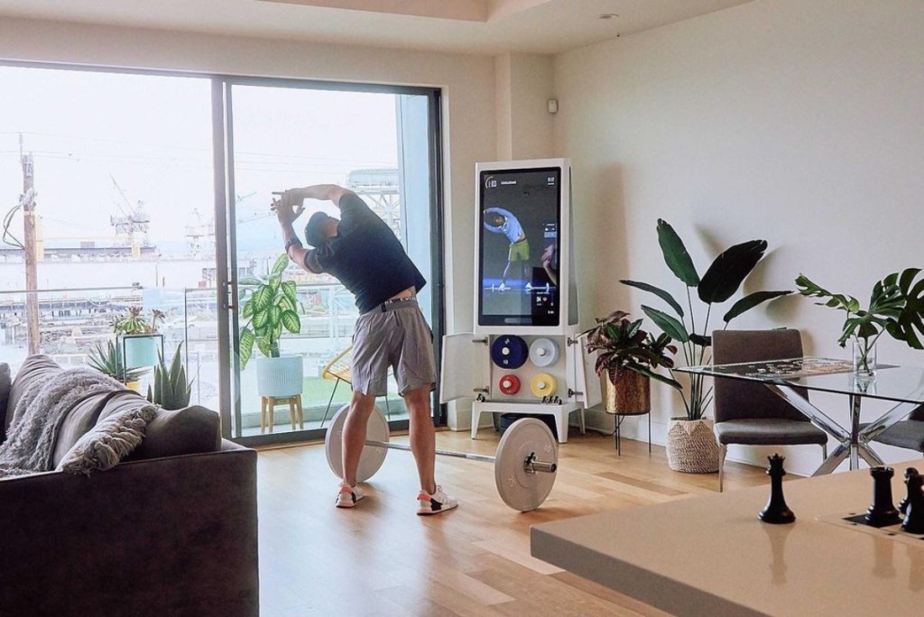 man stretching in front of workout mirror