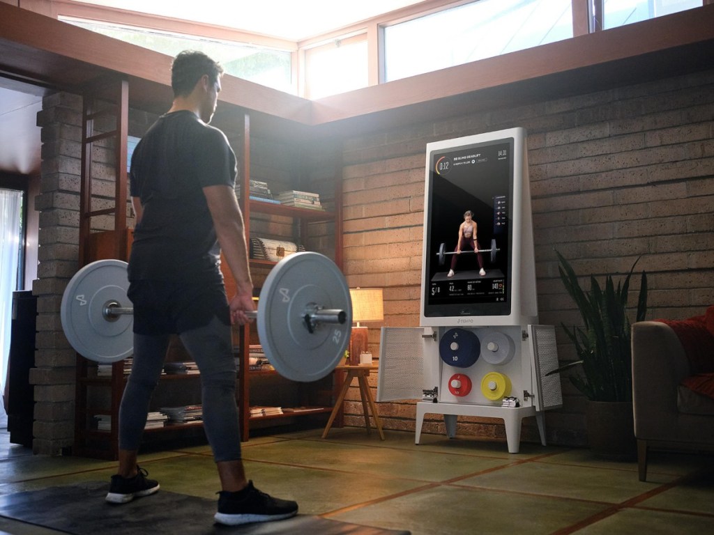 man lifting weights in front of Tempo Studio workout mirror