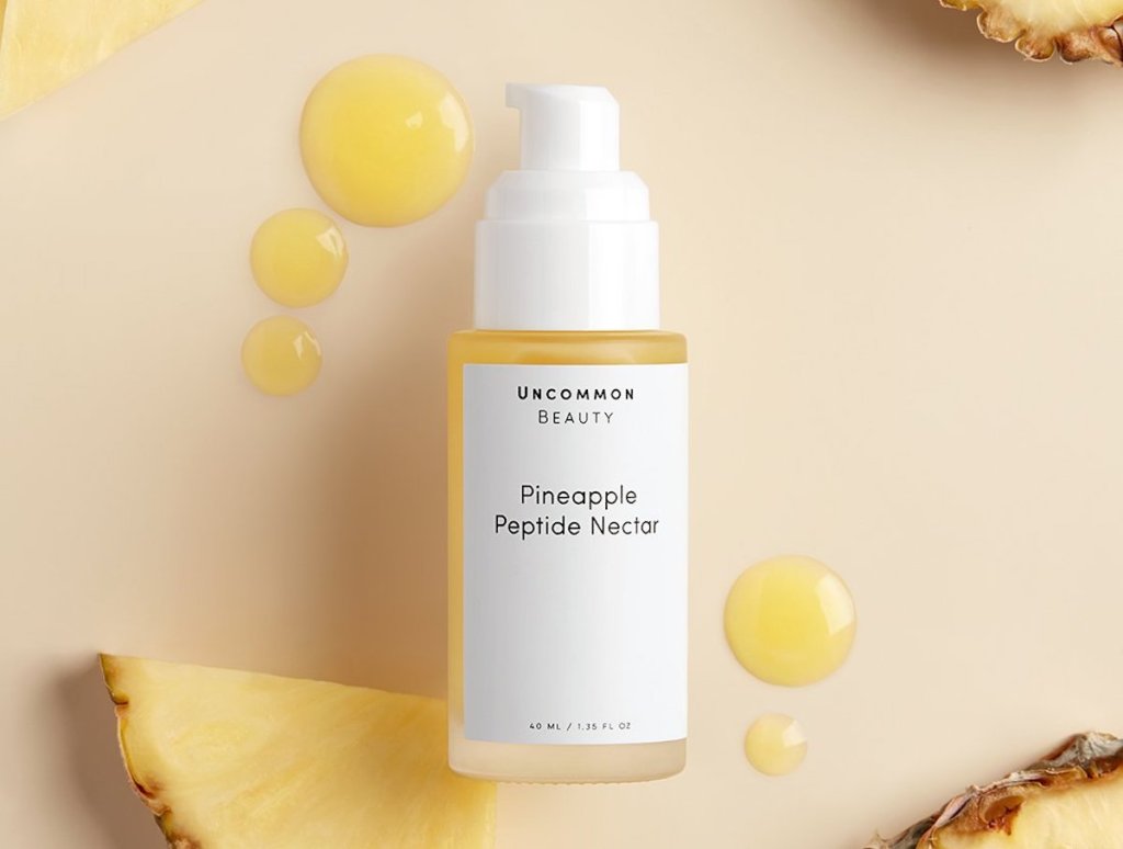 uncommon james beauty pineapple peptide nectar vitamin c serum on flatlay with fresh fruit