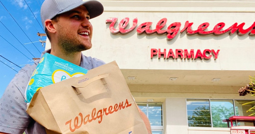 man carrying a Walgreens bag in front of a Walgreens store