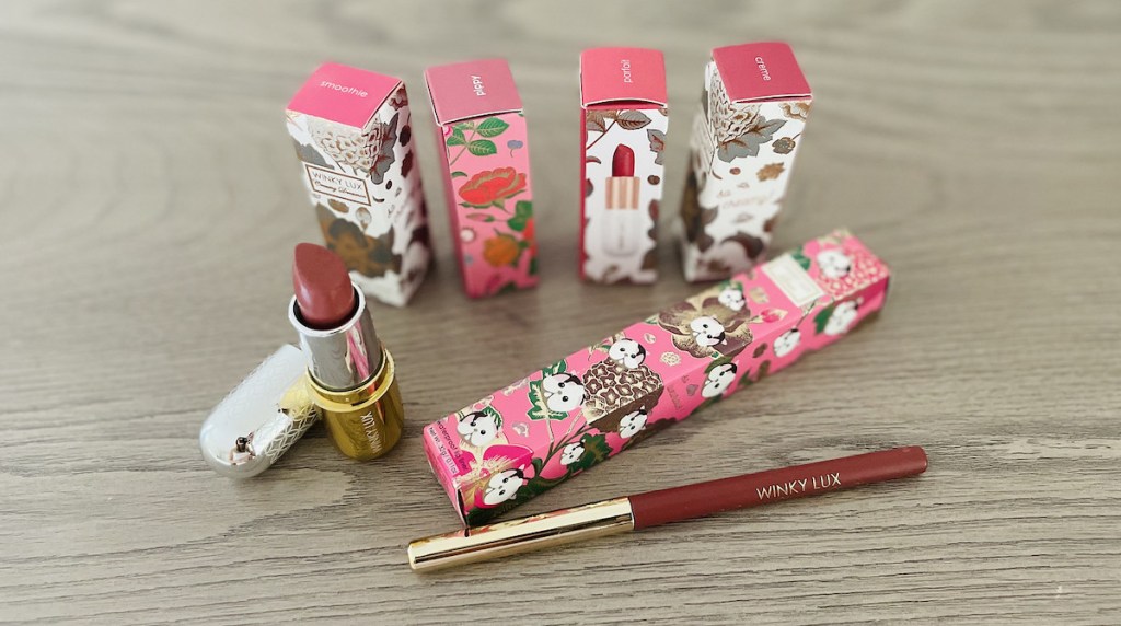 lipsticks and lipliner in winky lux boxes sitting on gray wood dresser