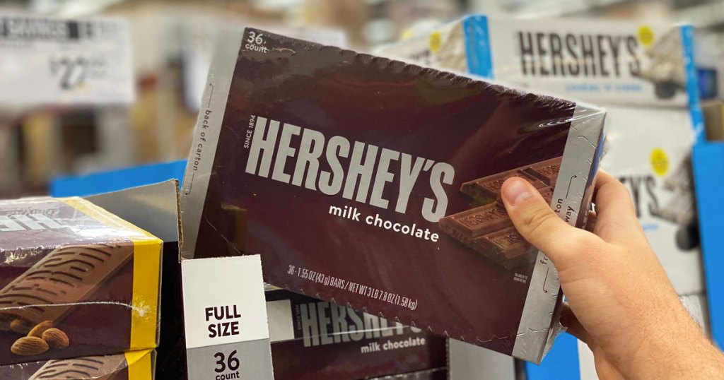 hand grabbing box of hershey's bars at sam's club