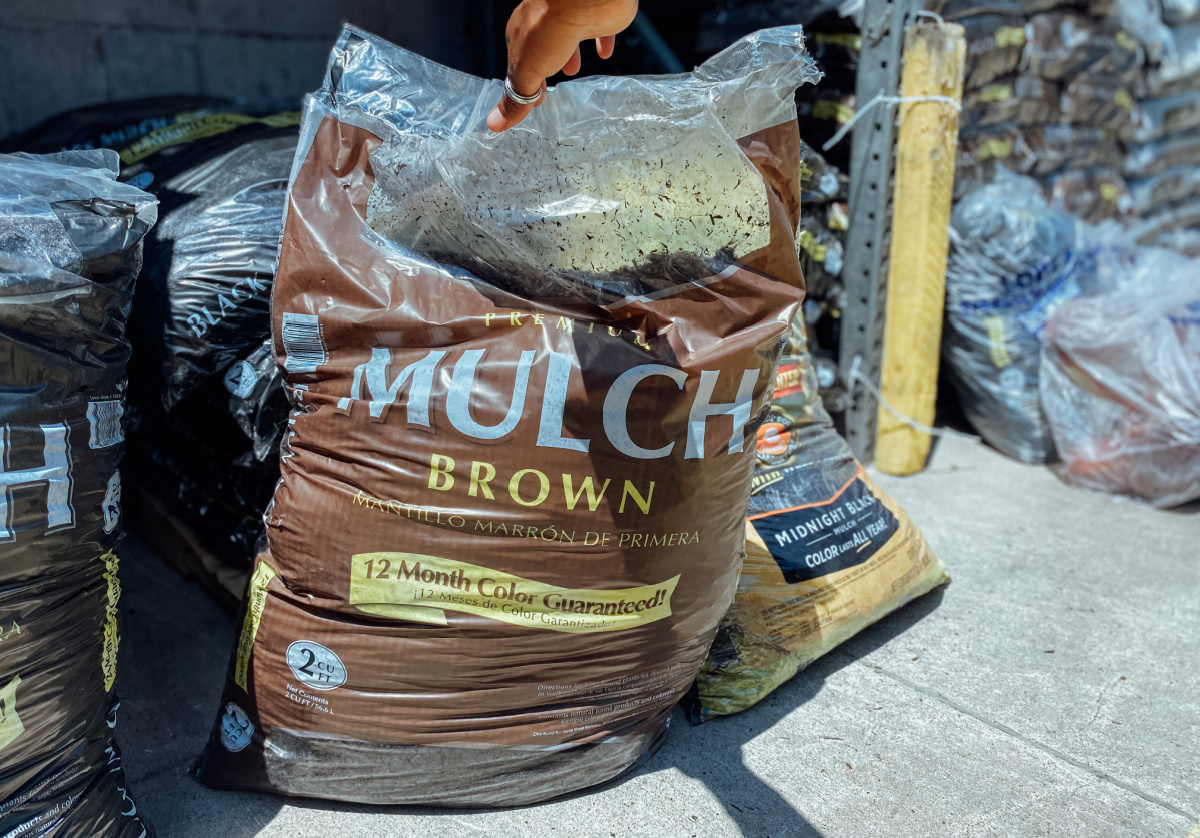 hand holding up large bag of mulch