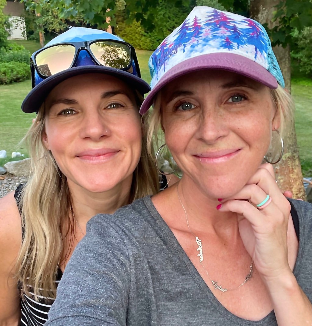 two women taking a selfie wearing hats and sunglasses