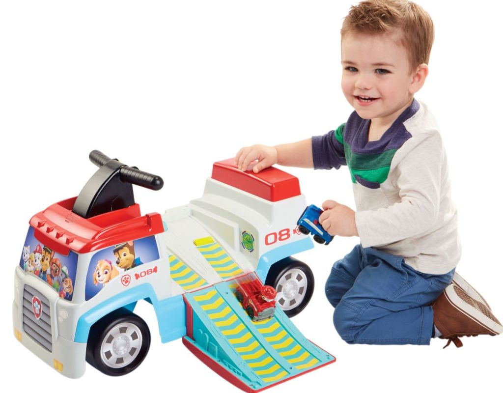 boy playing with a Paw Patrol ride-on