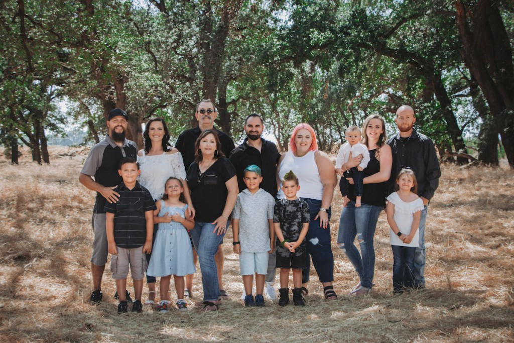 large group of people standing in woods together