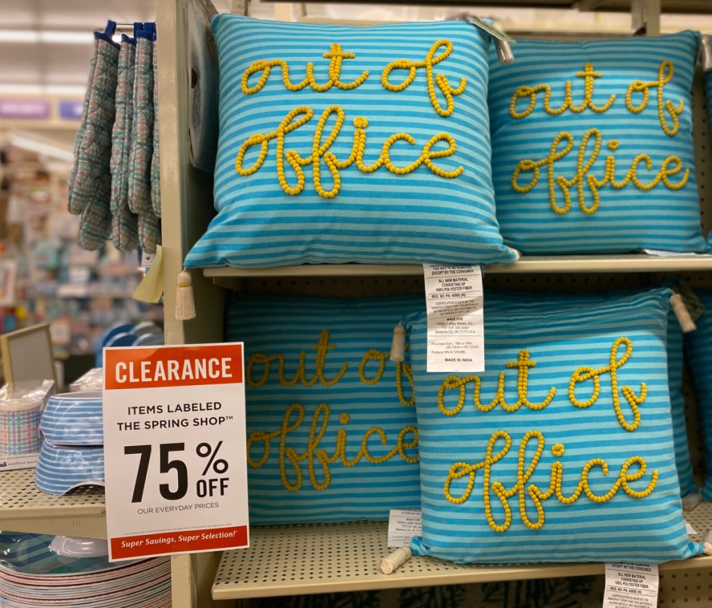 "out of office" tassled throw pillows on display in-store