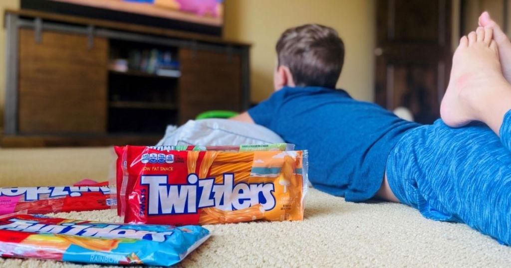 child watching a movie with Twizzlers