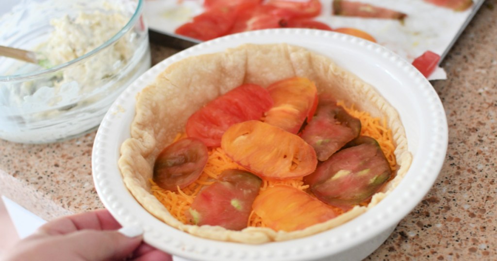 adding tomato slices to tomato pie