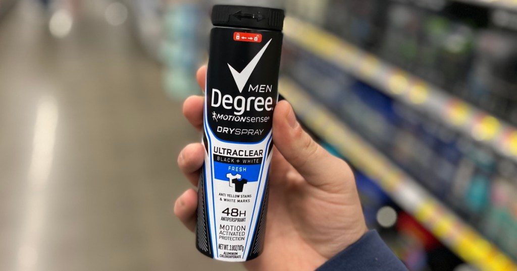 hand holding bottle of men's deodorant spray in store