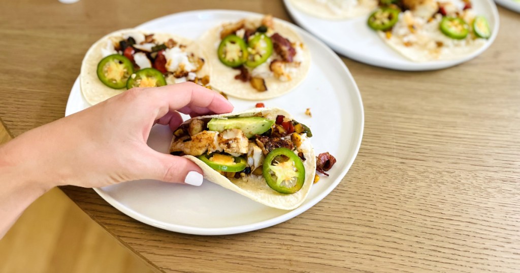 woman's hand holding a fish taco