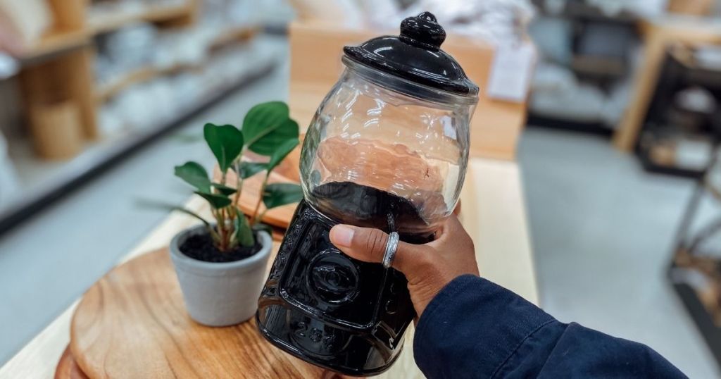 hand holding black gumball machine