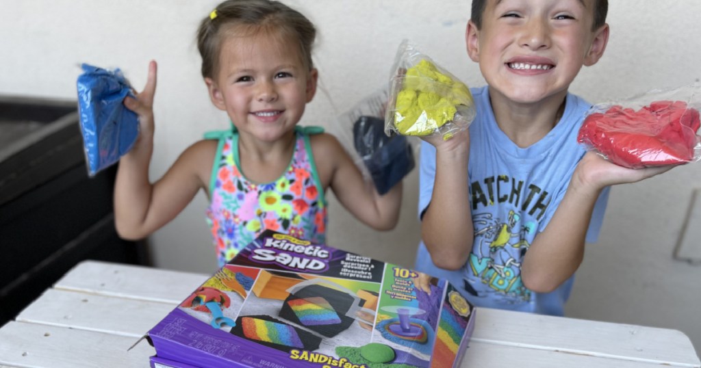 kids holding bags of kinetic sand