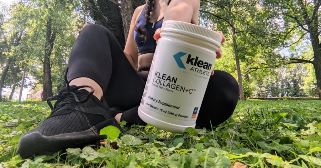 woman sitting on ground holding collagen + vitamin c powder