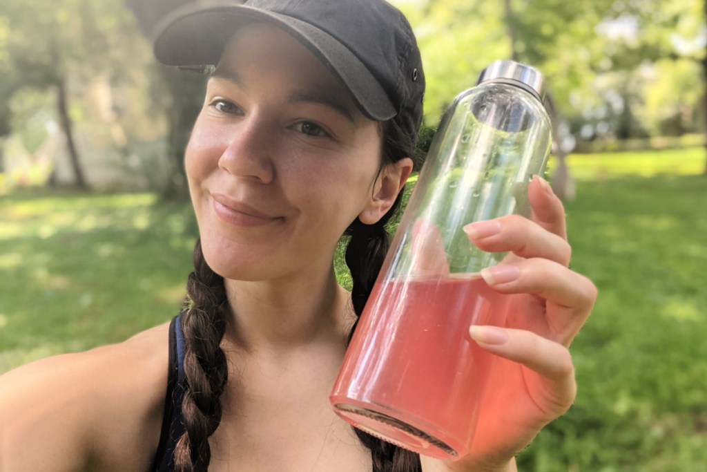 woman holding a water bottle with Klean Athlete Collagen+C supplement