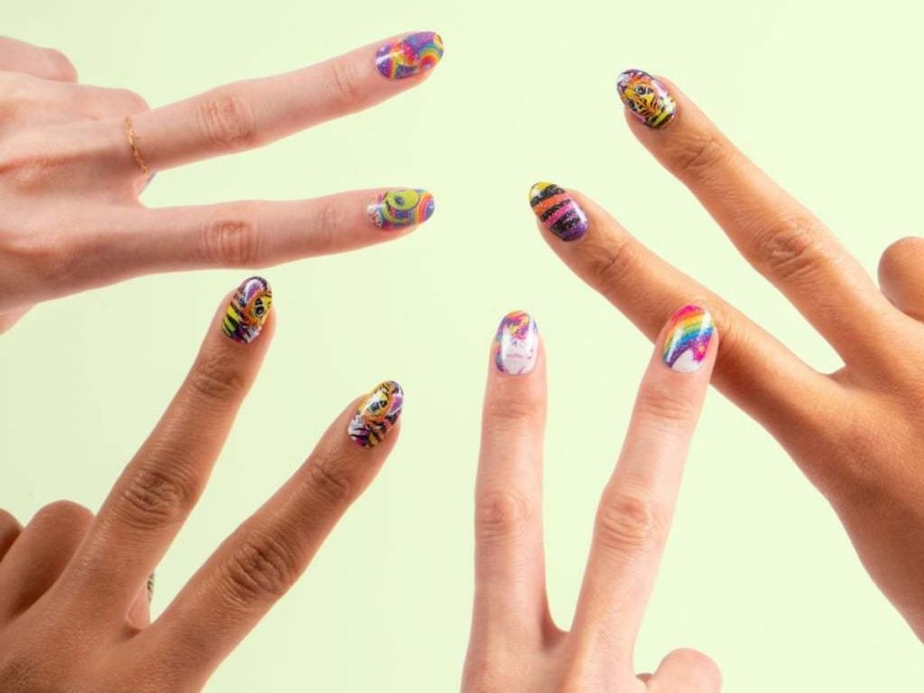 hands giving peace sign with designs on nails