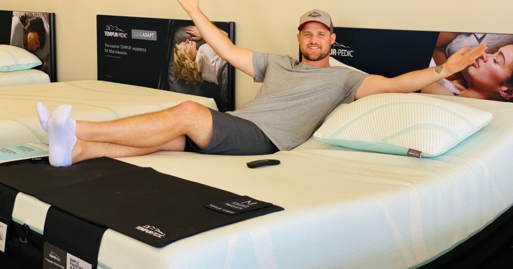 man laying on mattress in store