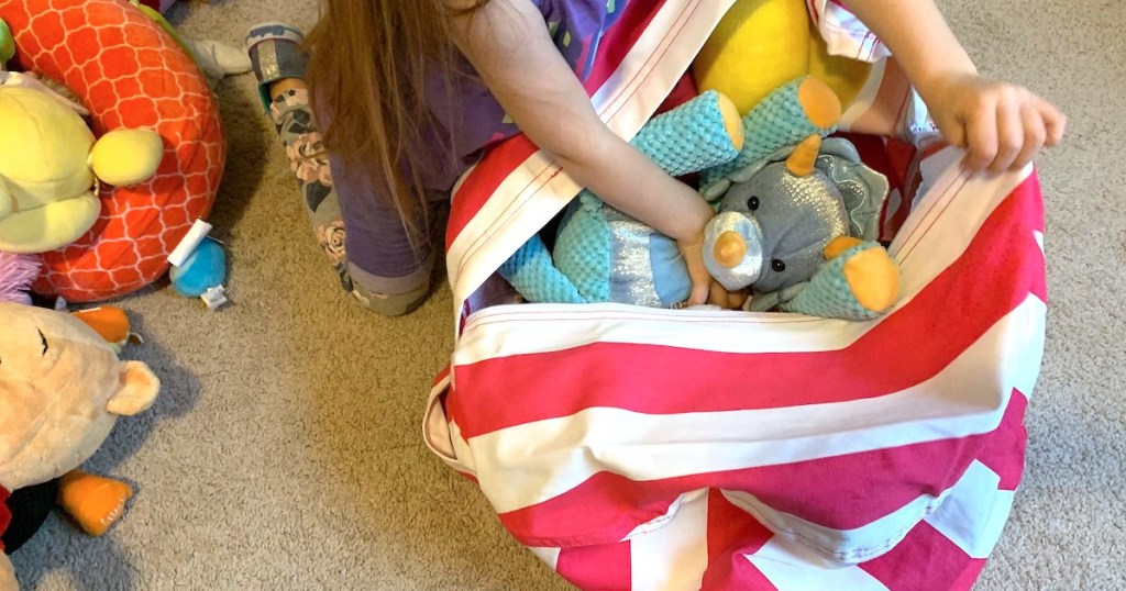 girl putting plush toys in a bean bag
