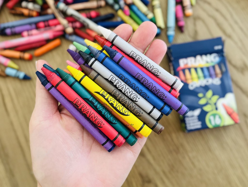 hand holding a pile of prang crayons