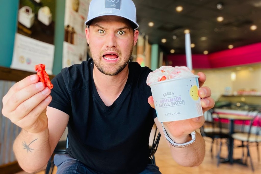 Man holding ice cream and hot Cheeto