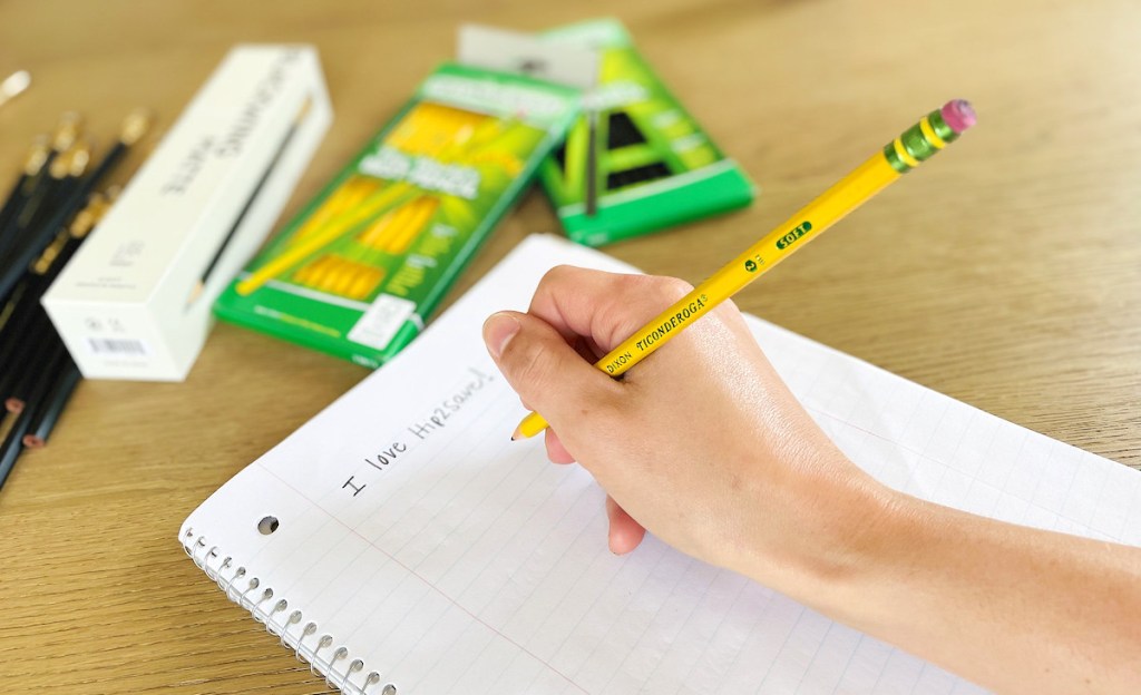 hand holding the worlds best pencil on notebook paper