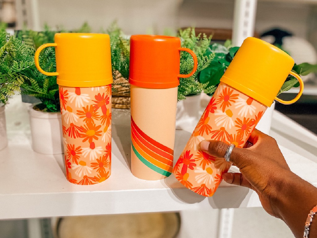 hand holding orange floral water bottle