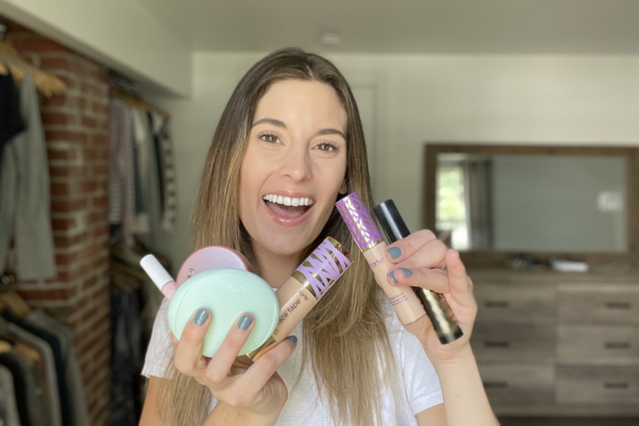 woman holding tarte cosmetics in bedroom