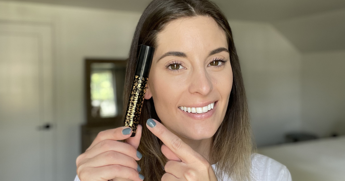 woman holding tarte maneater mascara that she bought thanks to a QVC promo code 2023