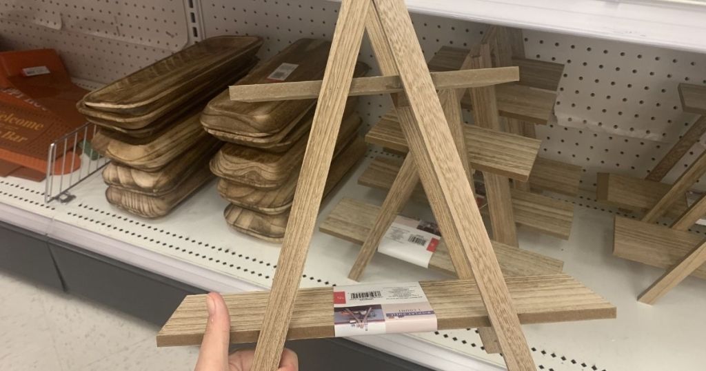 hand holding up a folding wooden tiered tray