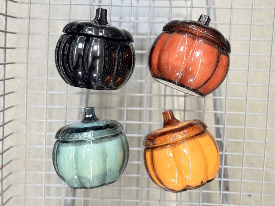 four glass pumpkin jar candles in shopping cart