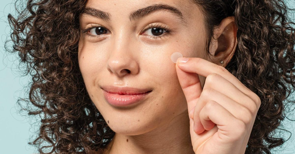 woman applying COSRX acne patches